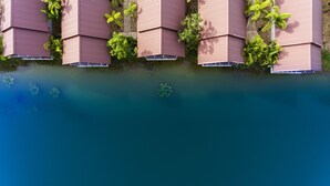 A row of pink buildings with a water body in front. - Tamali Hotel (Phra Phrom)