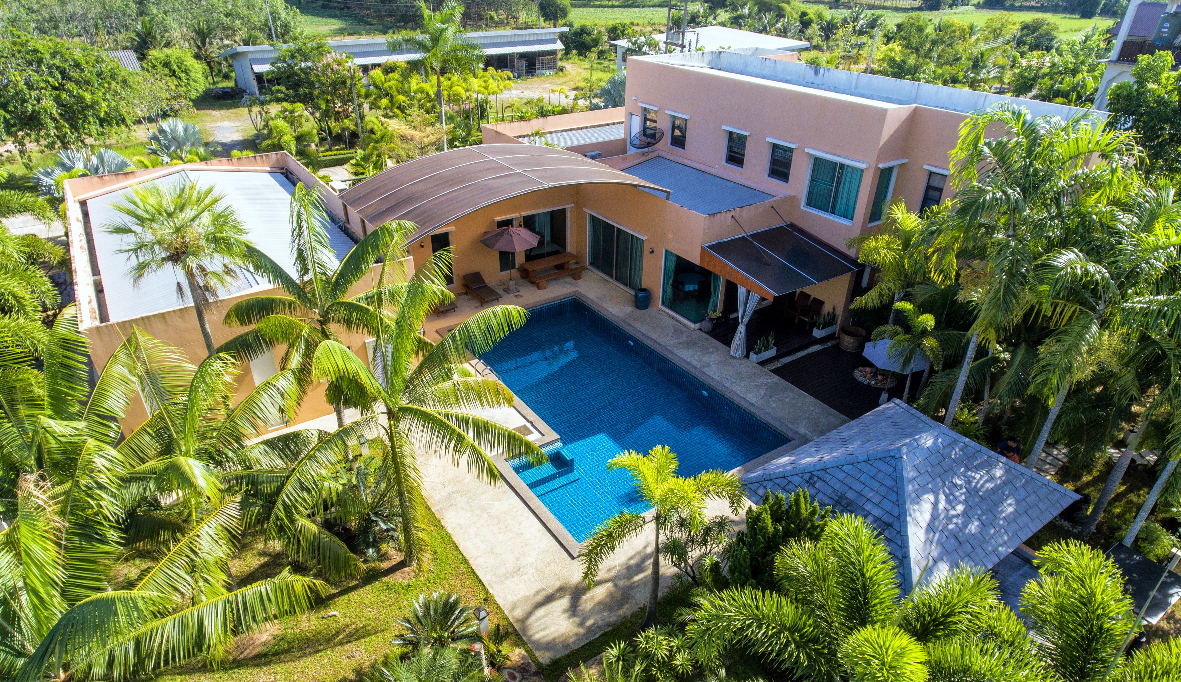 A modern house with a swimming pool surrounded by lush greenery.