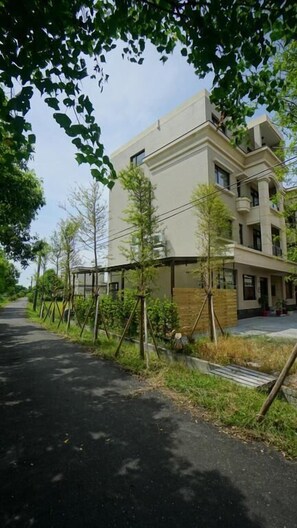 A multi-story building with a flat roof and a balcony on the second floor.