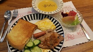 A plate with toast, scrambled eggs, a hot dog, and cucumber slices.