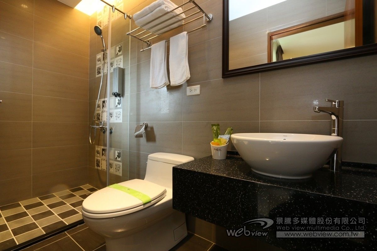 A modern bathroom with a shower, toilet, and sink.