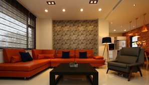 A modern living room with a sectional sofa, a coffee table, and a side table. - Riverbank Villa (Luodong)