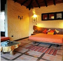 Una habitación acogedora con una cama, una mesita pequeña y un cuadro colgado en la pared.
