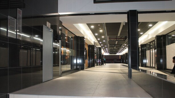 A modern indoor corridor with glass walls and a tiled floor, leading to a staircase. - 77 On Independence Windhoek (Windhoek)