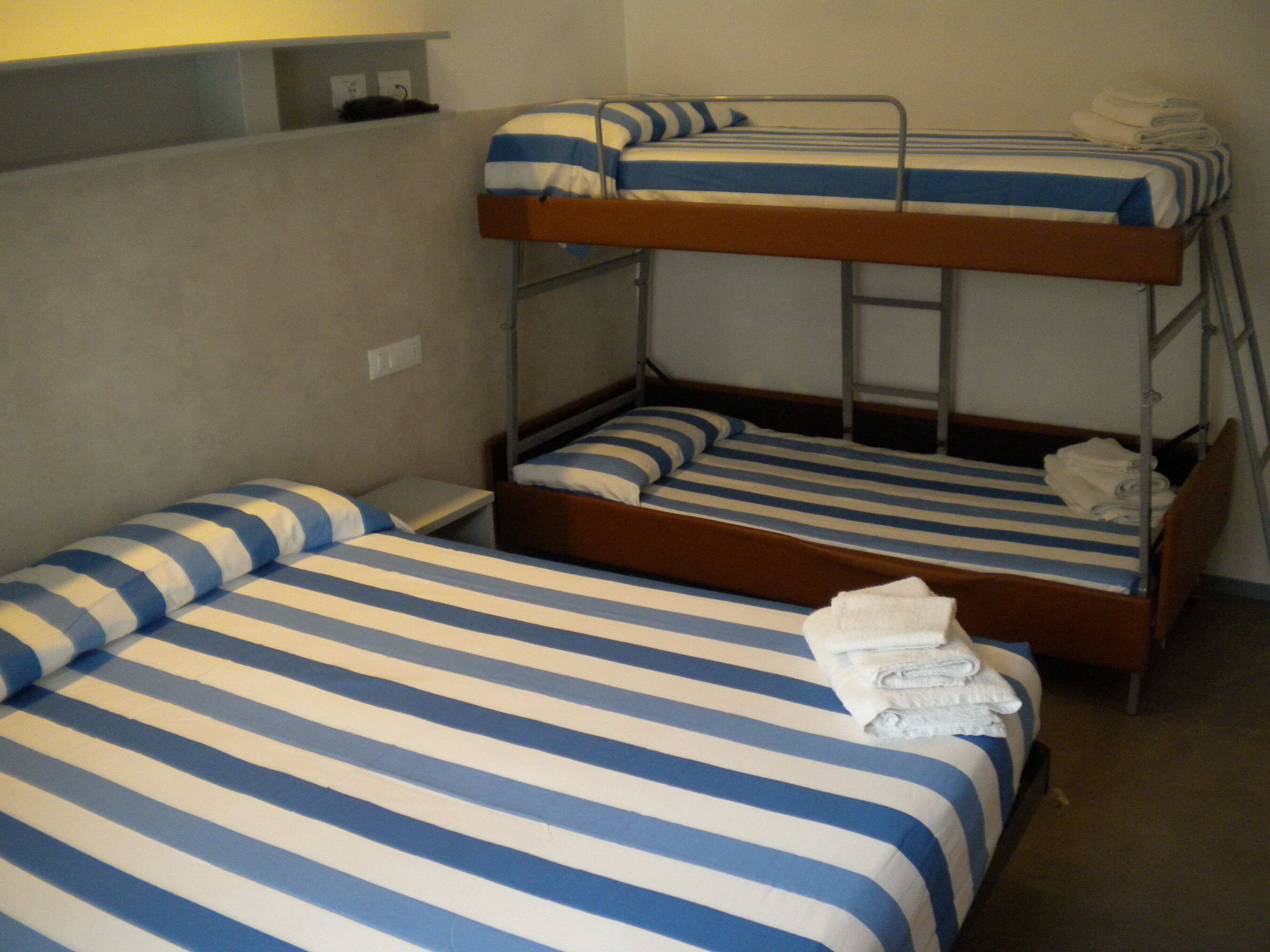 Una habitación con literas, cada una con ropa de cama a rayas.