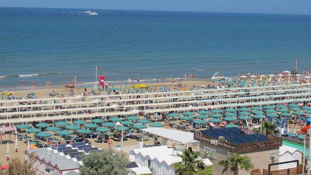 A beach resort with multiple levels of sunbeds and umbrellas, a pool area, and a view of the sea. - Hotel Ambasciata (Riccione)