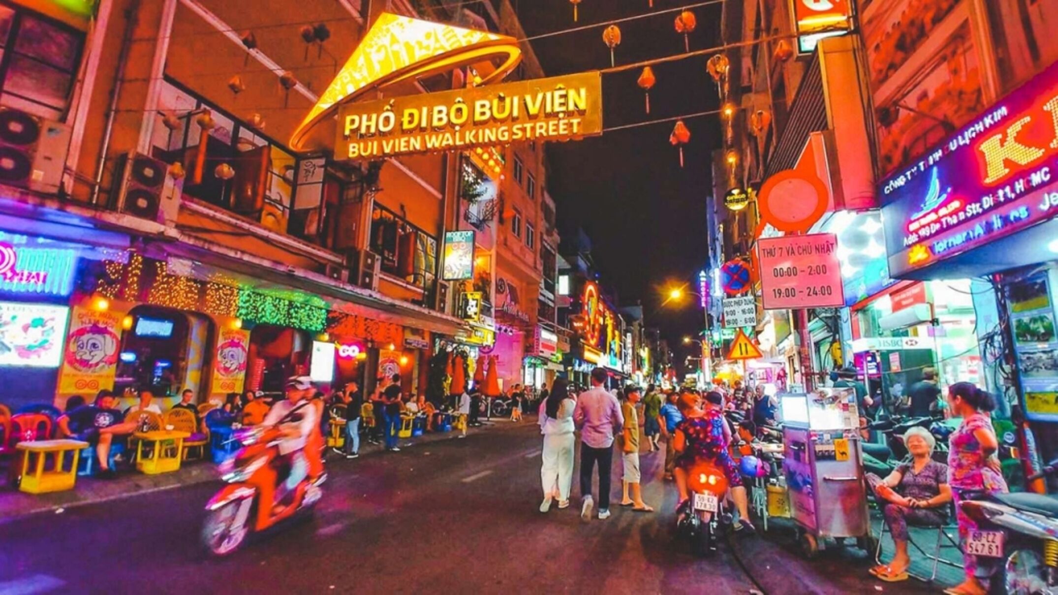 A bustling street scene with neon signs and street vendors.