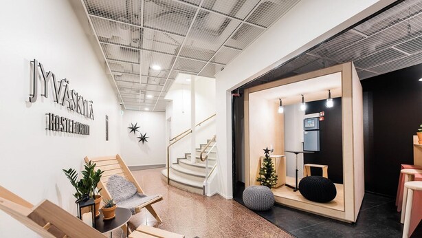 A modern interior with a staircase, seating area, and a reception desk. - Forenom Hostel Jyväskylä (Jyväskylä)