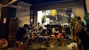 A restaurant with outdoor seating, a wooden facade, and a sign above the entrance. - M House (Hualien City)