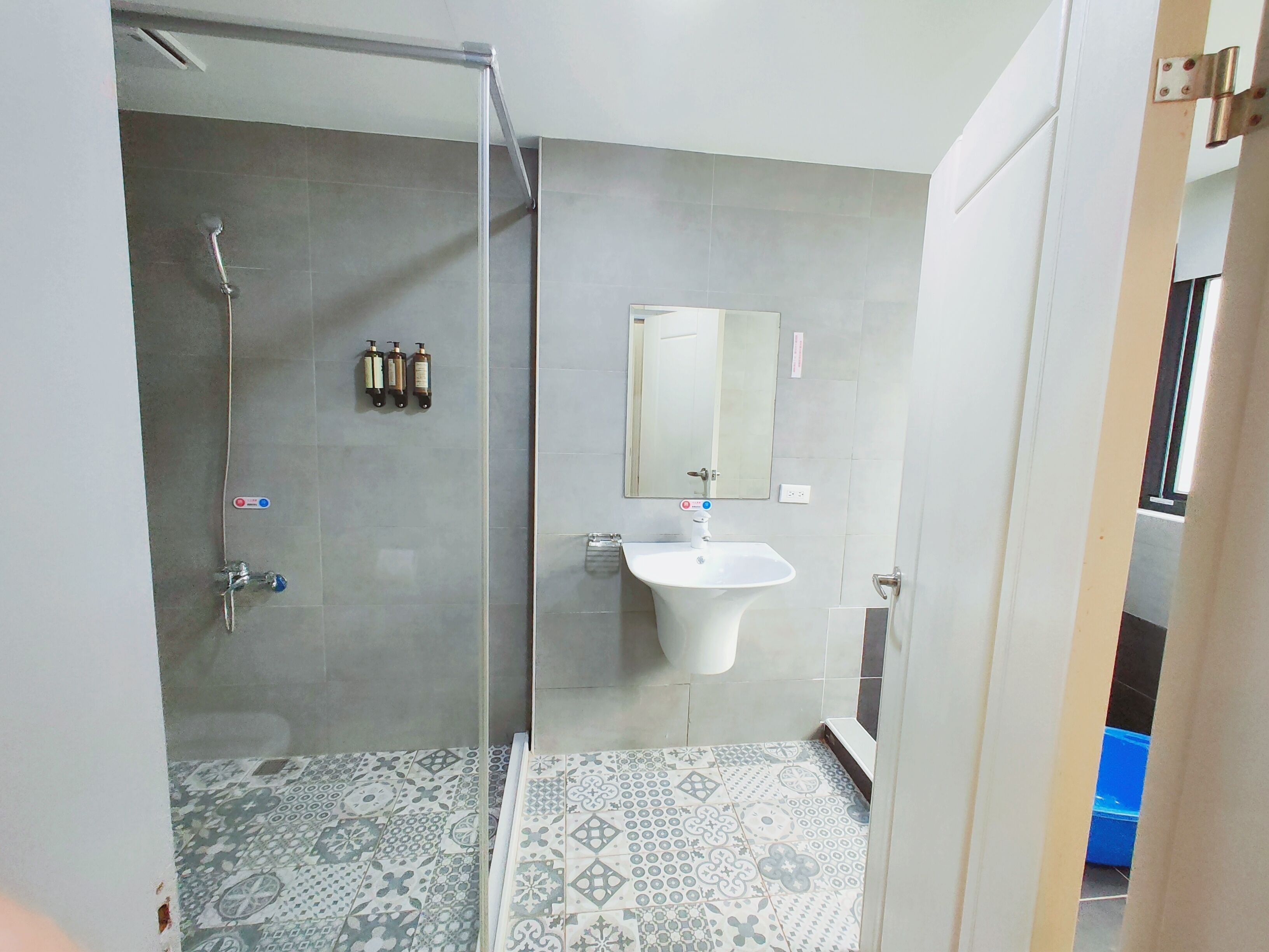 A bathroom with a shower, sink, and mirror.