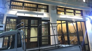 A multi-story building with traditional architectural features, including ornate window shutters and a balcony.