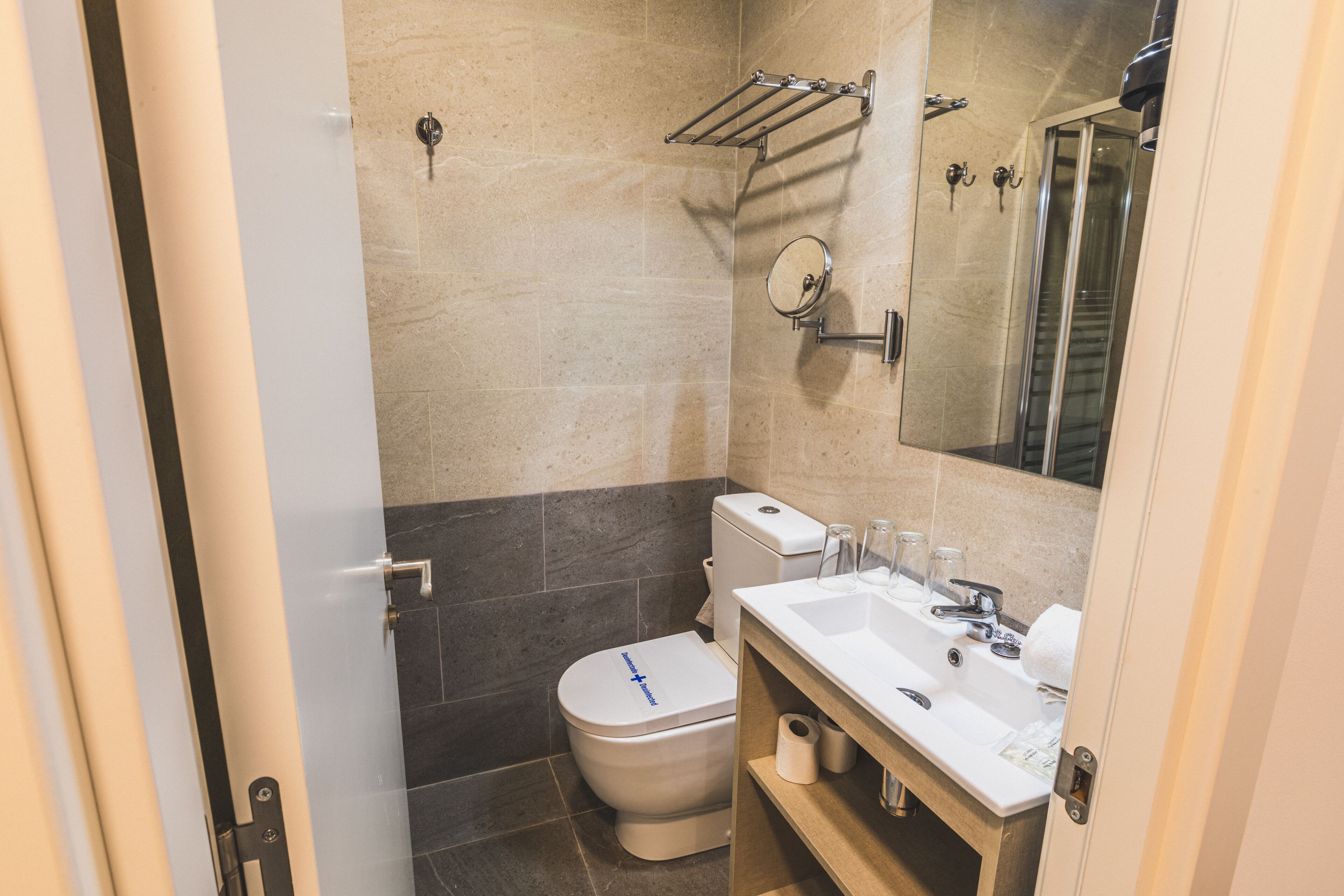 Een moderne badkamer met toilet, wastafel en douche.