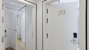 A modern hotel corridor with a number 20 door, a digital lock, and a glass partition. - Fontanella Green House (Barcelona)