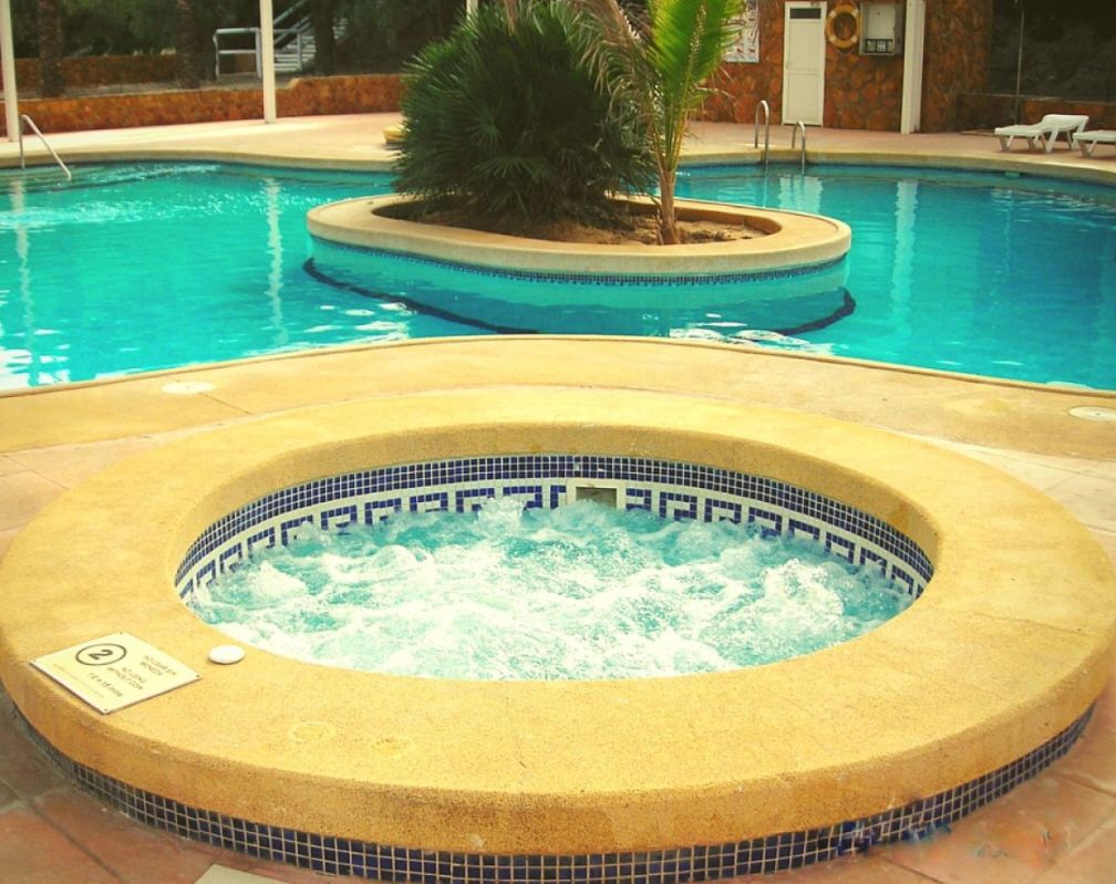 Una piscina al aire libre de temporada, tumbonas