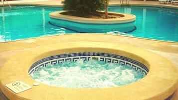 Una piscina al aire libre de temporada, tumbonas