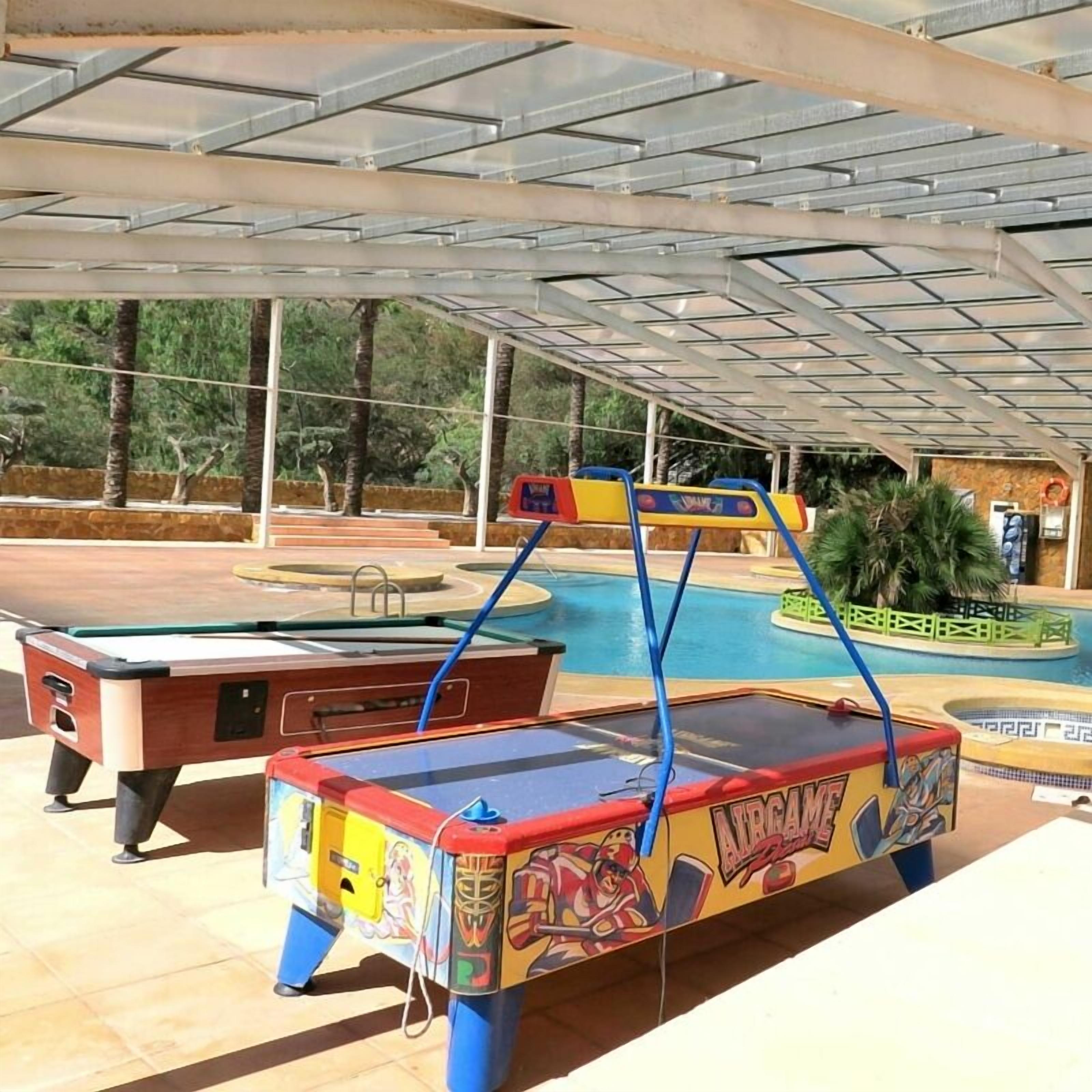 A poolside area with a pool table and a table tennis table.