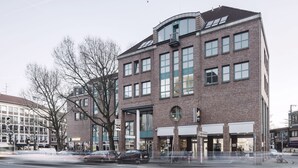 Un edificio de varios pisos con grandes ventanales y fachada de ladrillo.
