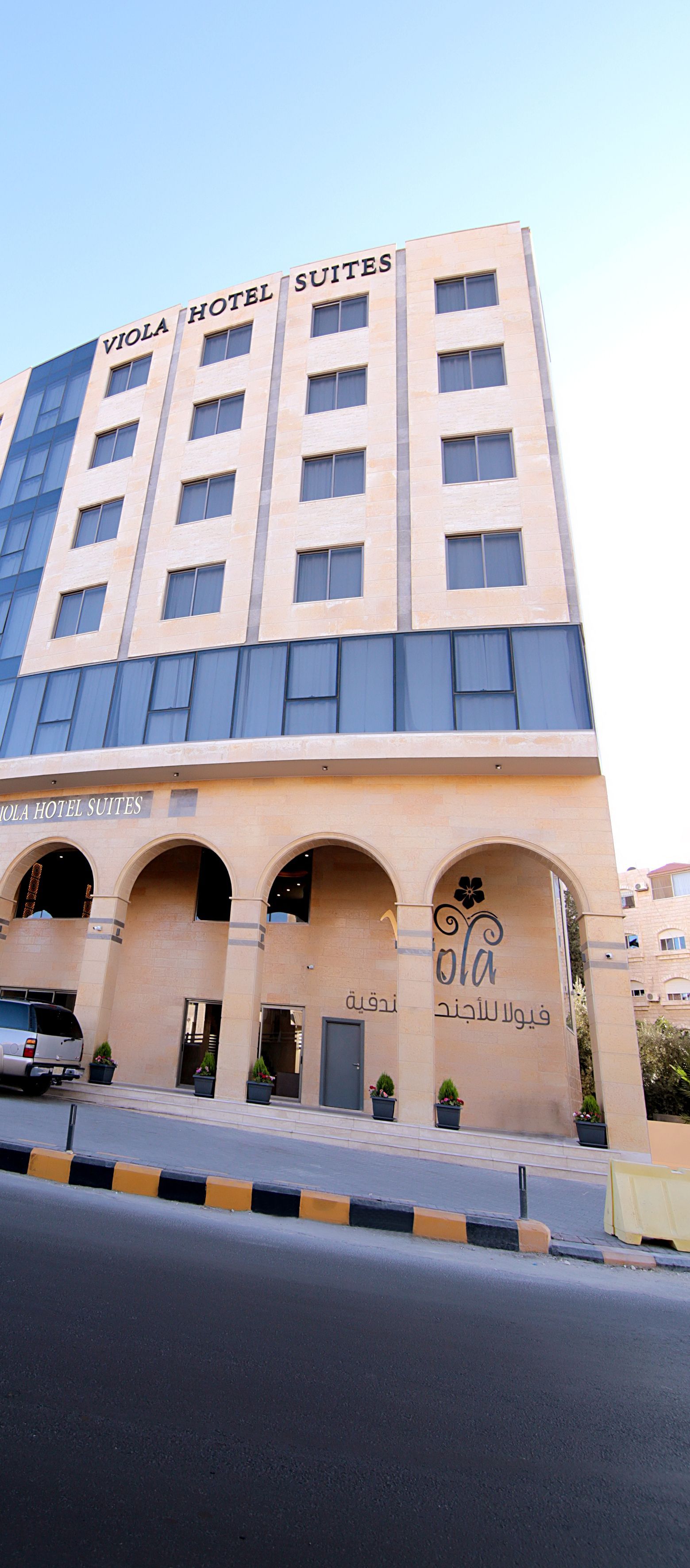 A building with the sign "Vola Hotel Suites" indicating it is a hotel.