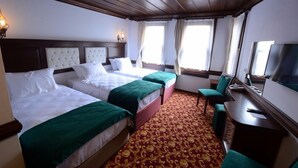 Hotellihuone, jossa on kaksi sänkyä, työpöytä ja televisio.