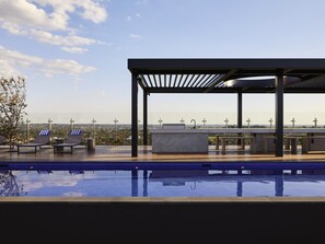 Una piscina al aire libre, sillones reclinables de piscina