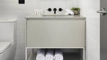 Un baño con inodoro, lavabo y espacio para toallas.