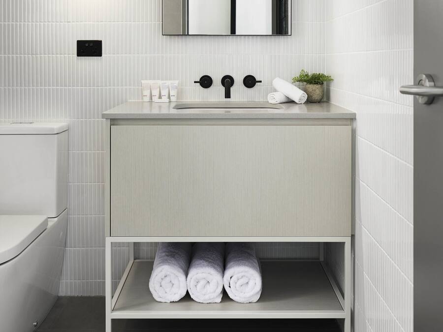 Un baño con inodoro, lavabo y espacio para toallas.