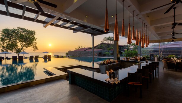 A poolside bar area with a view of the sunset, outdoor seating, and a pool. -  Regenta Arie Lagoon Negombo (Negombo)