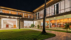 A modern building with a stone facade, large windows, and a well-lit interior. -  Regenta Arie Lagoon Negombo (Negombo)