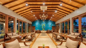 A spacious lobby with wooden ceiling beams, large windows, and a central seating area with sofas and tables. -  Regenta Arie Lagoon Negombo (Negombo)