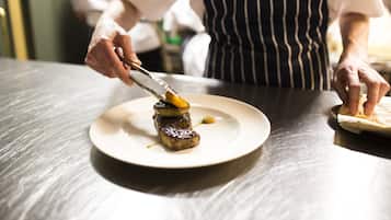 A chef preparing food on a plate.