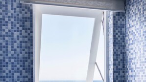 A bathroom with blue mosaic tiles, a window with a view of the sea, and a shower area. - Blue Anchor Lodge & Cafe-Binh Ba Island (Nam Cam Ranh)