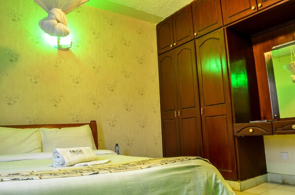 Una habitación de hotel con cama, armario y espejo.