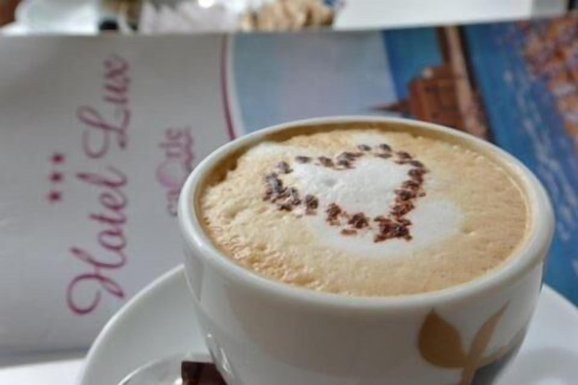 A cup of coffee with a heart-shaped design on the foam.