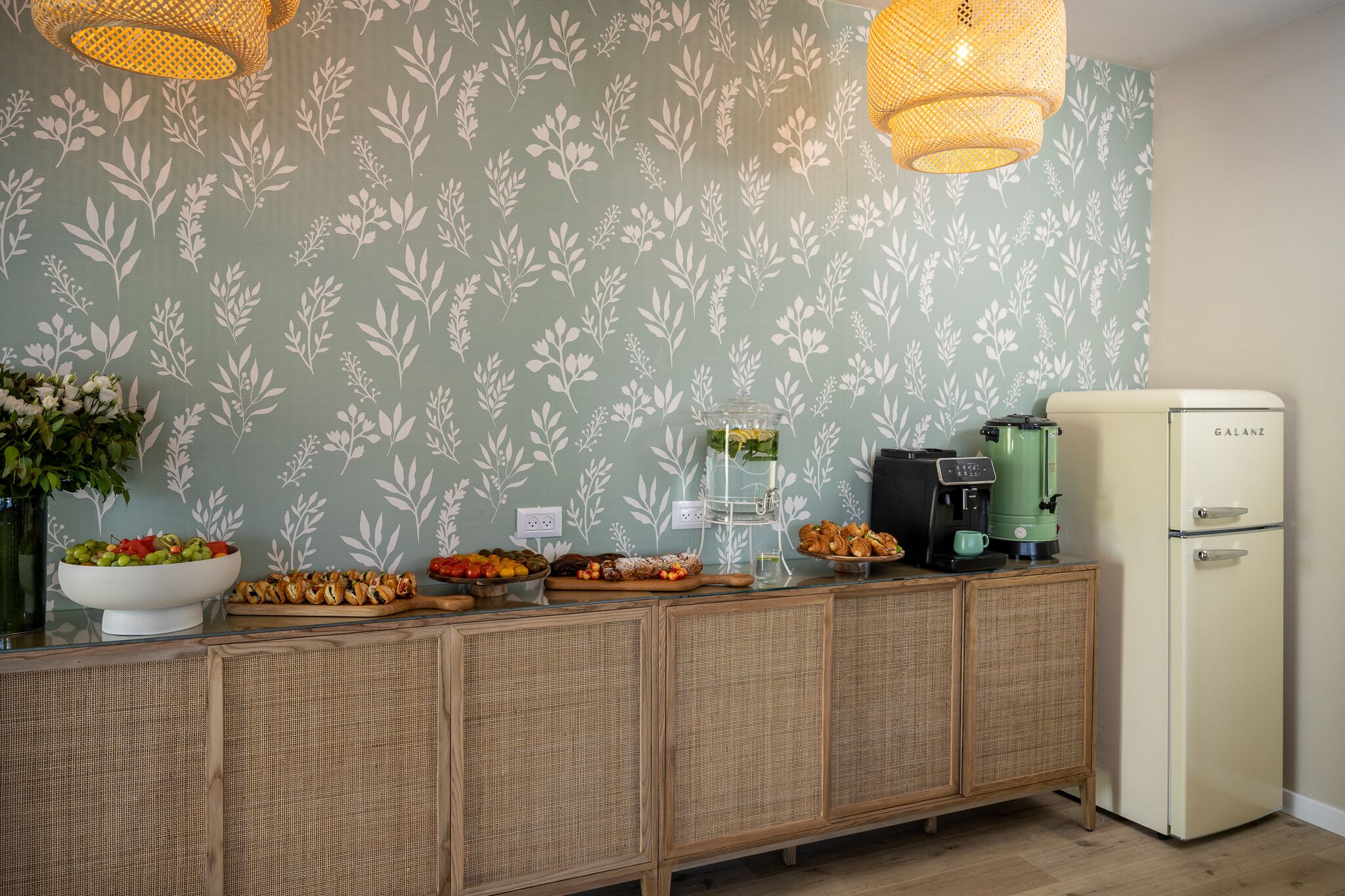 Een kitchenette met een Galanz-koelkast, een koffiezetapparaat en diverse etenswaren op het aanrecht.