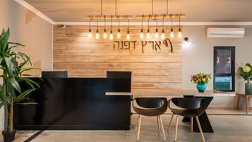 A modern reception area with a wooden wall, a black reception desk, and two black chairs.