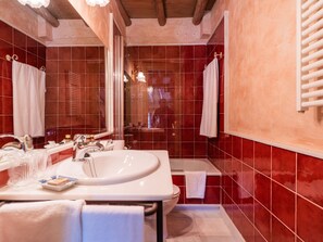 Un baño con un lavamanos grande, espejo y bañera.