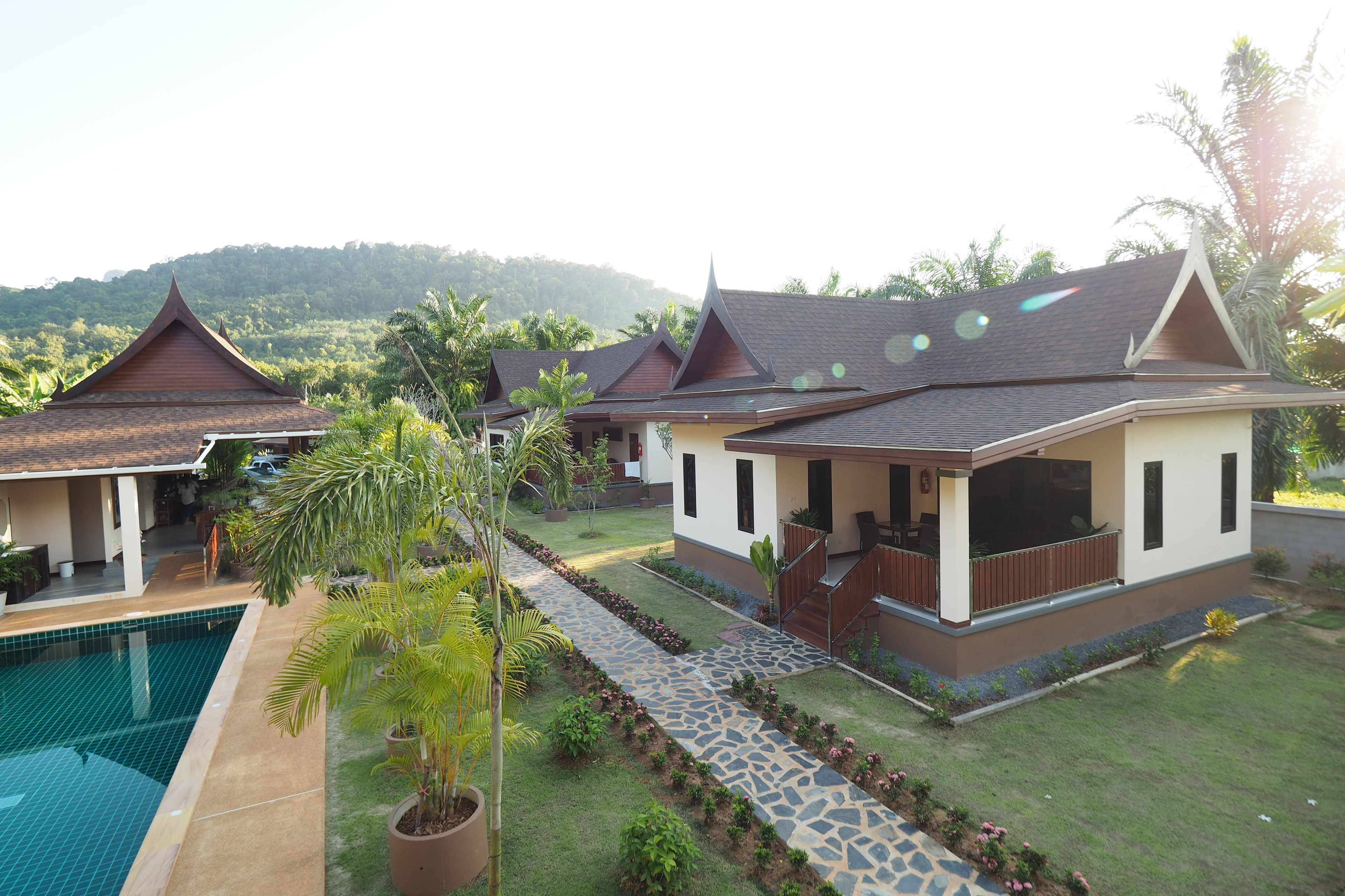 A resort with multiple bungalow-style buildings, a swimming pool, and a well-maintained garden.