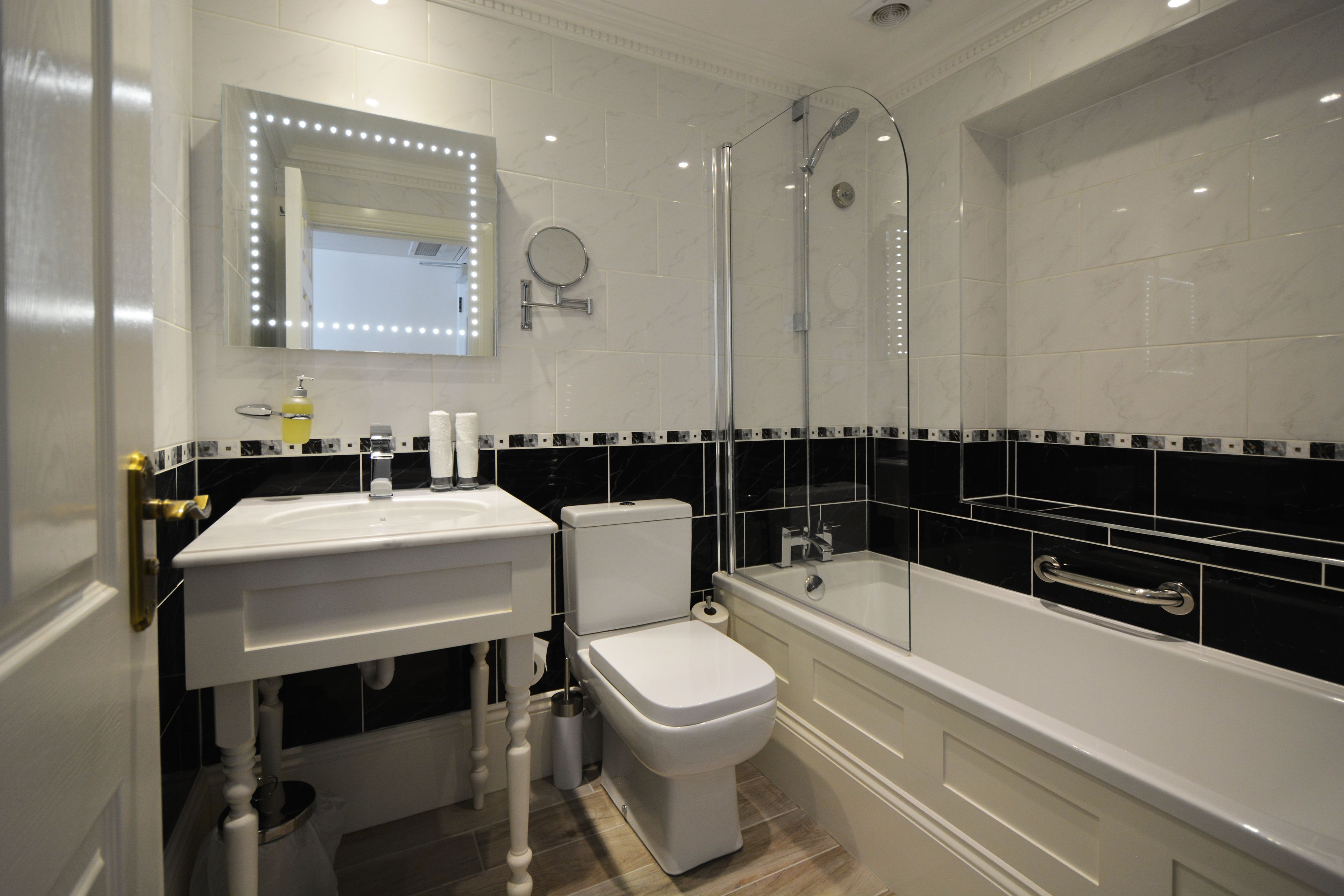Un baño moderno con lavamanos, inodoro y bañera blancos.
