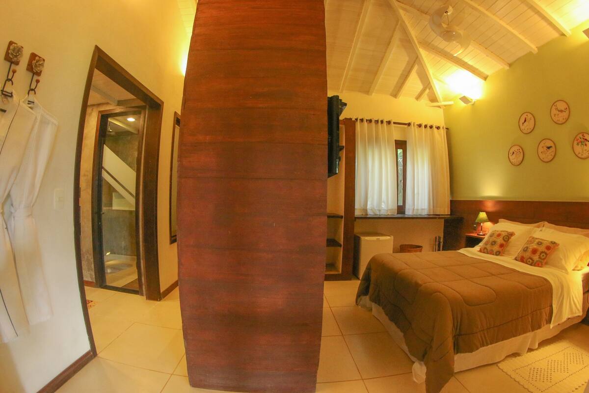 A bedroom with a bed, nightstand, and wall clocks.