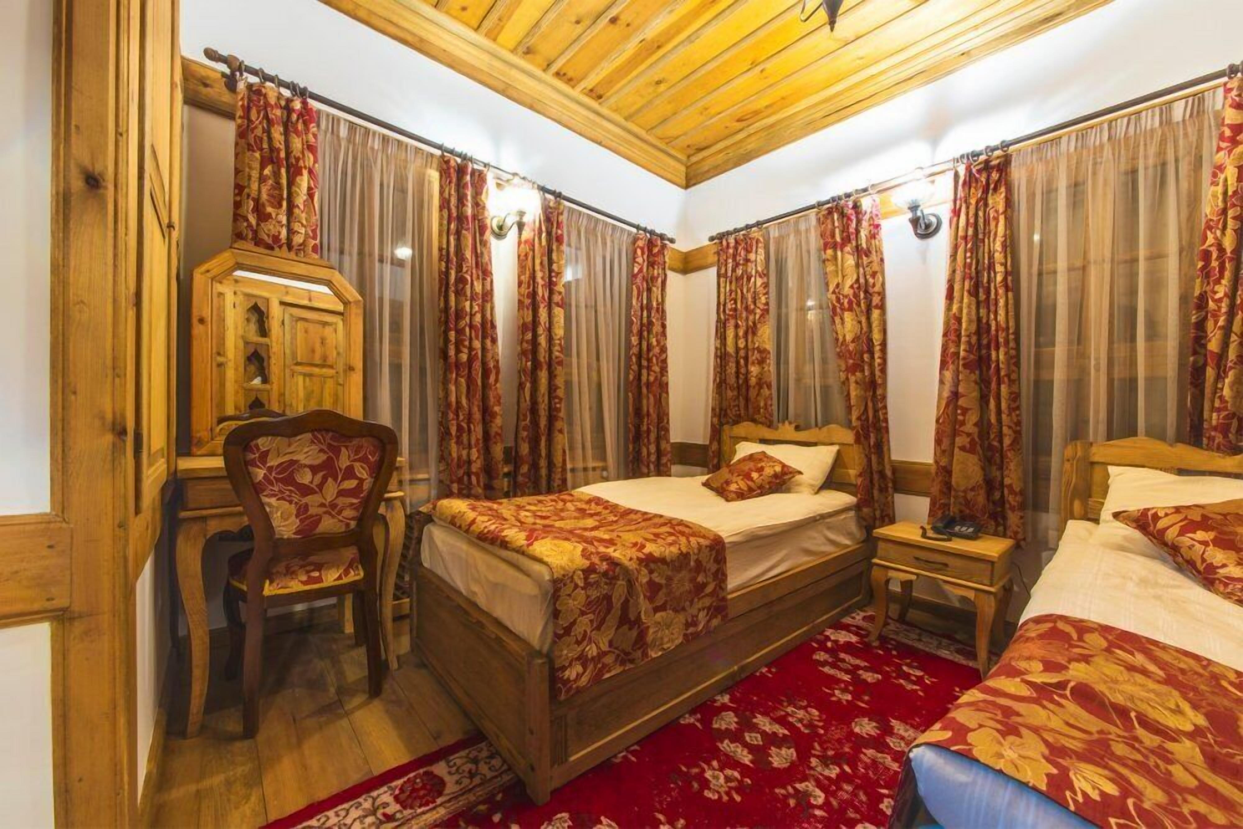 Une chambre avec deux lits en bois, un bureau et une chaise.
