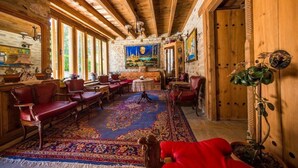 Ein gemütliches Holzinterieur mit einem großen Teppich, Ledersofas und einer Steinwand mit einem Gemälde.