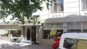 A building with a sign reading "KONYA HOTEL". There are outdoor chairs and a table near the entrance. A red car is parked in front. - Konya Hotel (Konya)