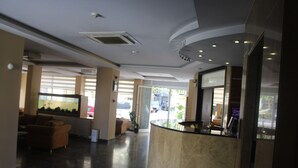 A lobby with a reception desk, seating area, and large windows. - Konya Hotel (Konya)