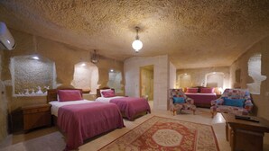Une chambre avec deux lits, un coin salon avec un canapé et une petite table.