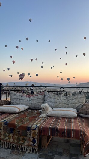 A bed with a view of hot air balloons at sunset. - Salkim Cave House (Nevsehir)