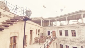 Un immeuble à plusieurs niveaux, doté d’un escalier, de balcons et d’une terrasse couverte.
