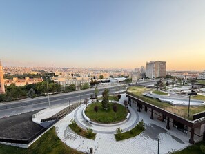 A modern urban area with a central roundabout, a large building with a flat roof, and a distant city skyline. - Hotel Sema (Ankara)