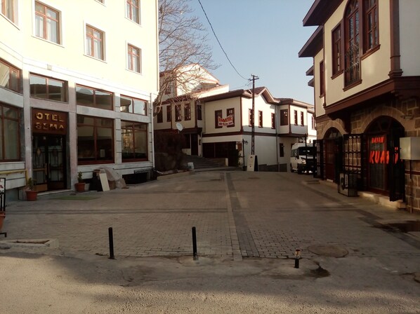 Una calle con edificios, incluyendo un hotel llamado "OTEL SEMA" y un restaurante llamado "BAYAN KUAT".