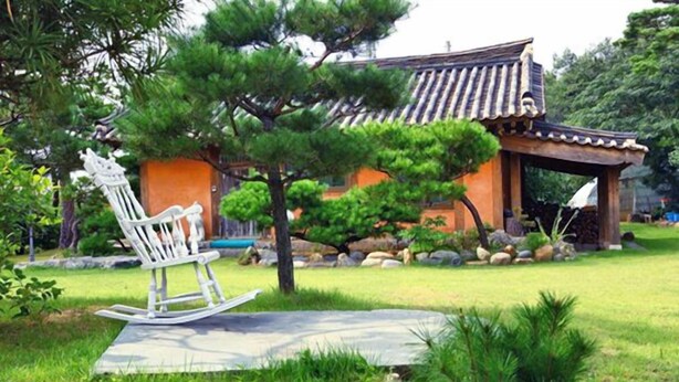 A traditional building with a tiled roof and a wooden structure in front.