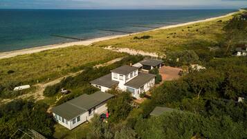 A coastal property with multiple detached houses, a beach, and a clear view of the ocean.